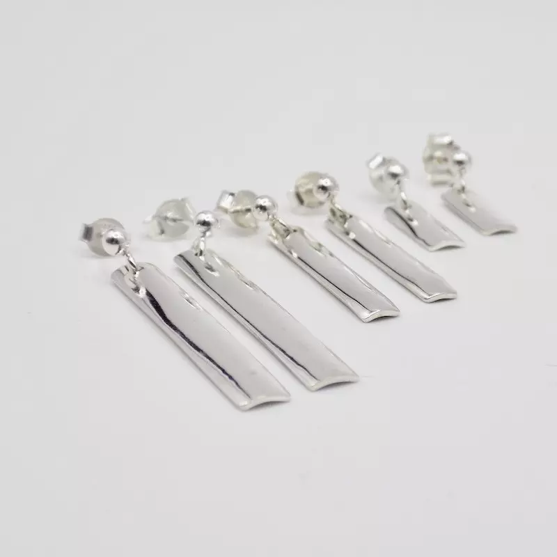 Photo de trois paires de boucles d'oreilles en argent. Elles ont chacune une longueur différentes.