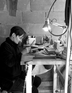 Nichelson Creation copie- artisan au travail- atelier moi en train de travailler à mon établi assise en face en pleine concentration
