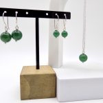 Photo couleur de deux paires de boucles d'oreilles. Elles sont formées de perle dAgate verte. Une fait 8mm de diamètre et l'autre 12mm. Puis sen association avec un pendentif perle aussi.