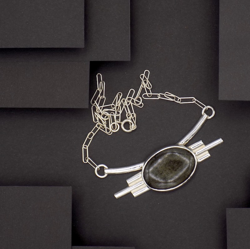 Photo de haut d'un argent. Serti d'une obsidienne dorée. Plastron