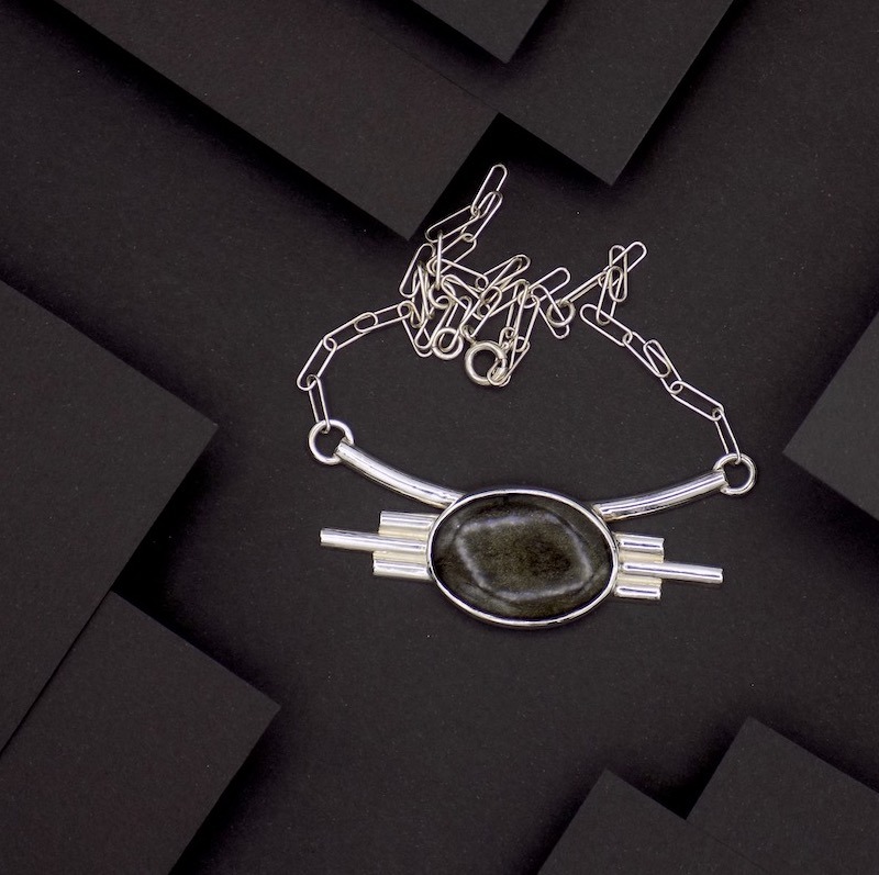 Photo de haut d'un collier en argent massif et serti d'une magnifique obsidienne dorée.