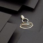 Photo design d'un pendentif ovale serti d'une Turquoise du Tibet.