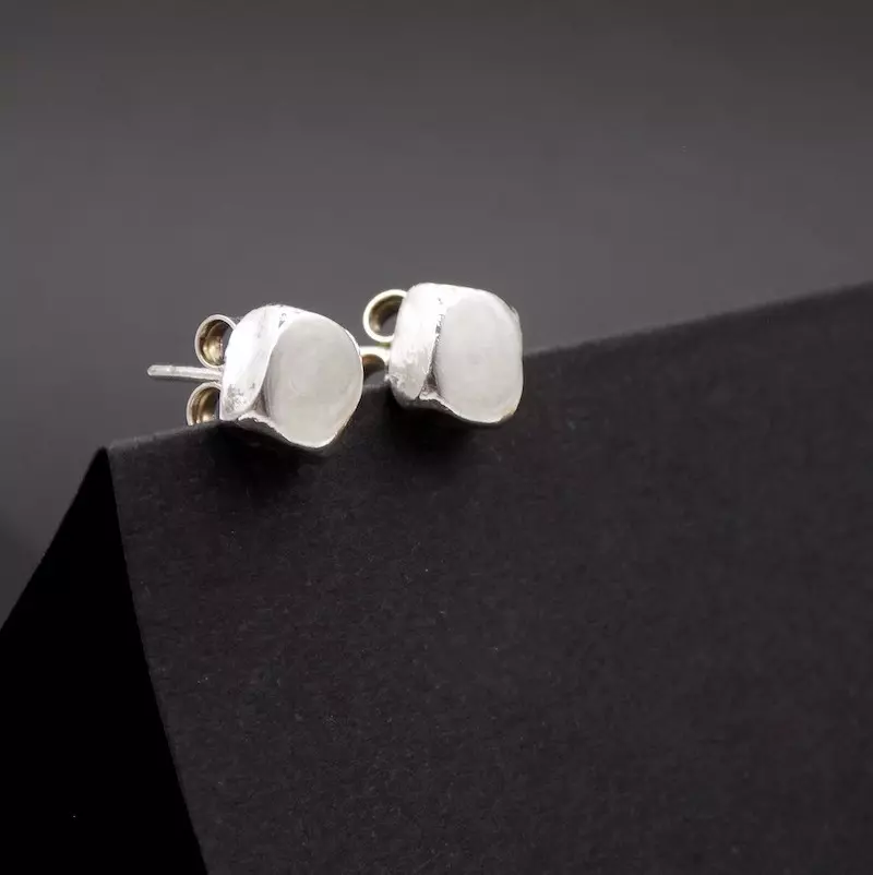 Photo de bijou. Une paire de boucles d'oreilles puce de forme carrée. formée comme un petit pavé en argent massif.