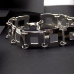 Photo d'un bracelet en argent. Ce bracelet est fait de plusieurs carré ajourés assemblés les uns derrière les autres.