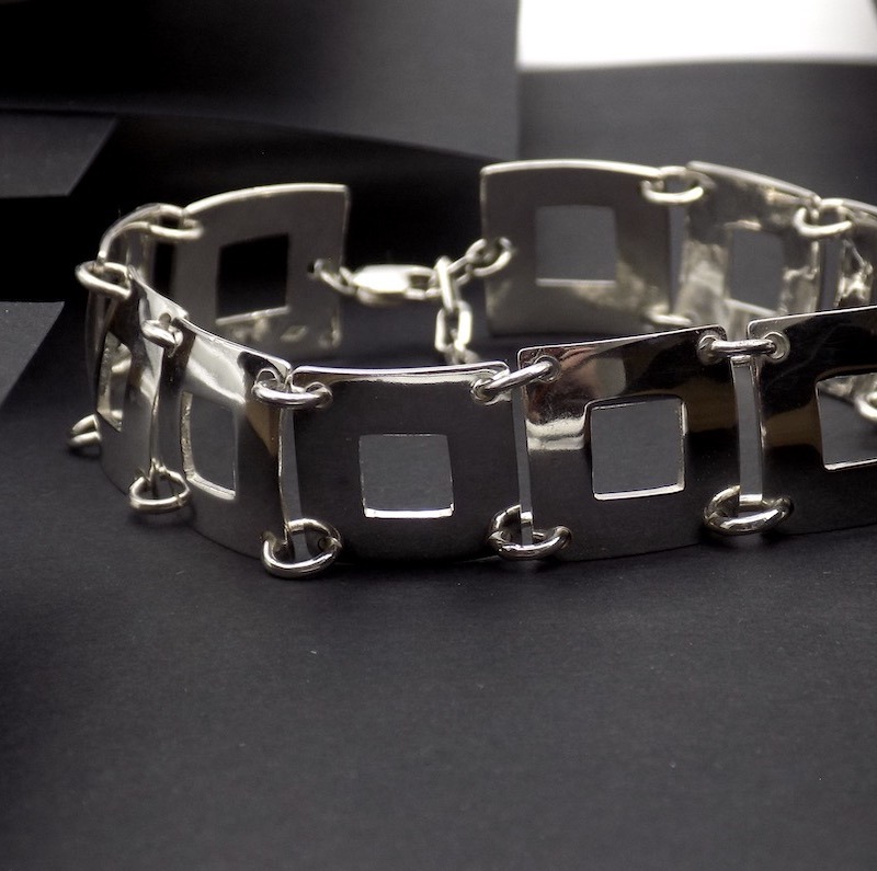 Photo d'un bracelet en argent. Ce bracelet est fait de plusieurs carré ajourés assemblés les uns derrière les autres.