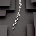 Photo vue de haut d'un pendentif long et en zigzag. Bijou de créateur en argent massif.