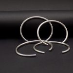 Photo sur fond noir de plusieurs bracelets ouverts en argent.