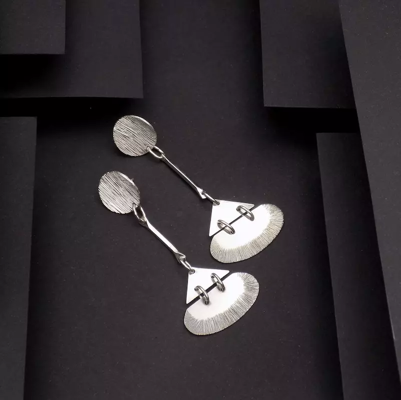 Photo prise de haut d'une paire de boucles posée sur un fond noir