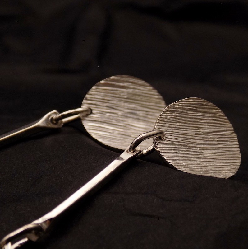 Gros plan d'une partie d'une paire de boucles d'oreille en argent