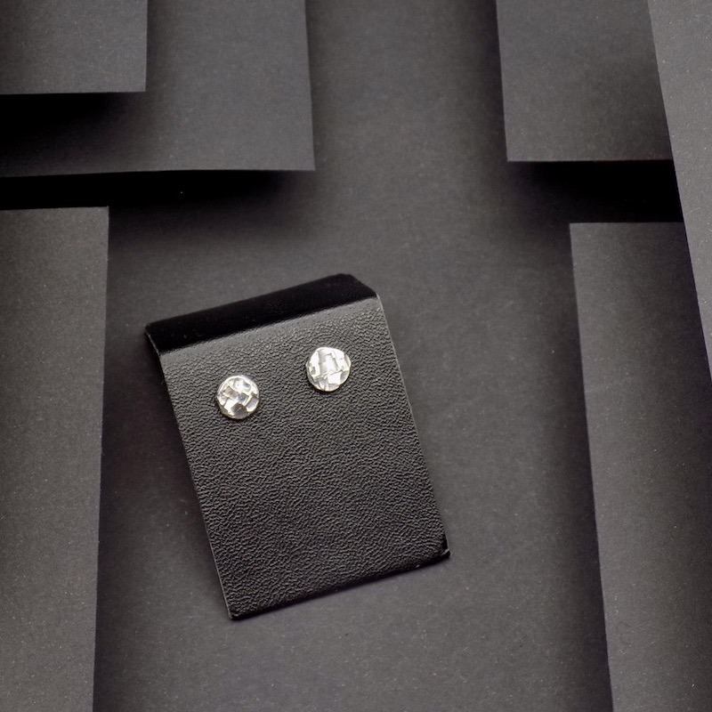 Photo prise de haut d'une paire de boucles d'oreilles sur un support.