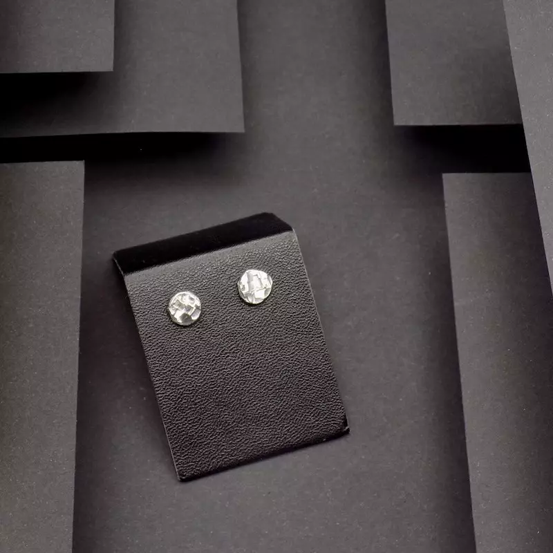 Photo prise de haut d'une paire de boucles d'oreilles sur un support.