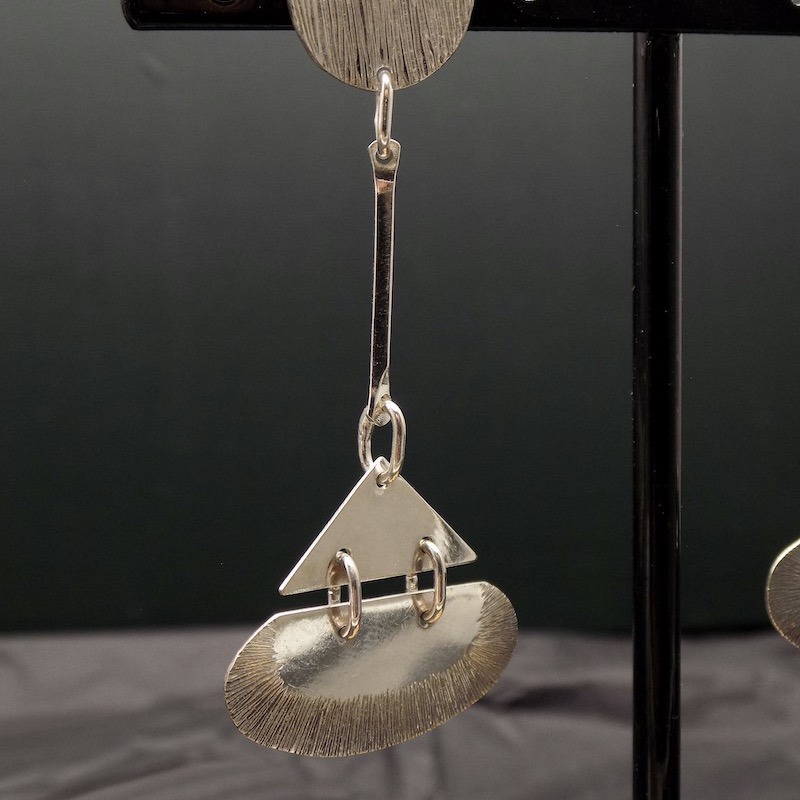 Photo d'une boucle en argent de style art déco accrochée pendante.