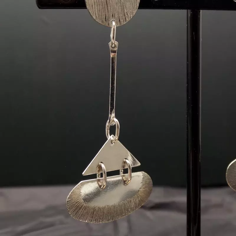 Photo d'une boucle en argent de style art déco accrochée pendante.