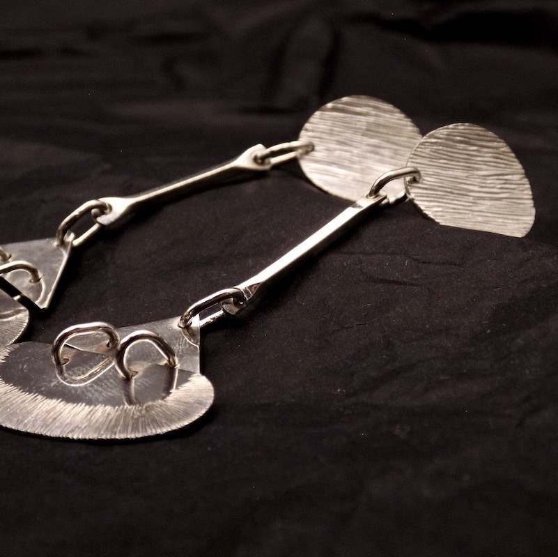 Photo d'une paire de boucles d'oreilles posée sur un fond noir