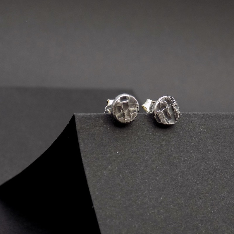 Photo gros plan d'une paire de boucles puces en argent martelé.