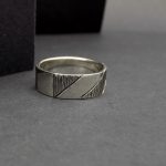 Photo d'une bague en argent 925 posée sur un fond noir