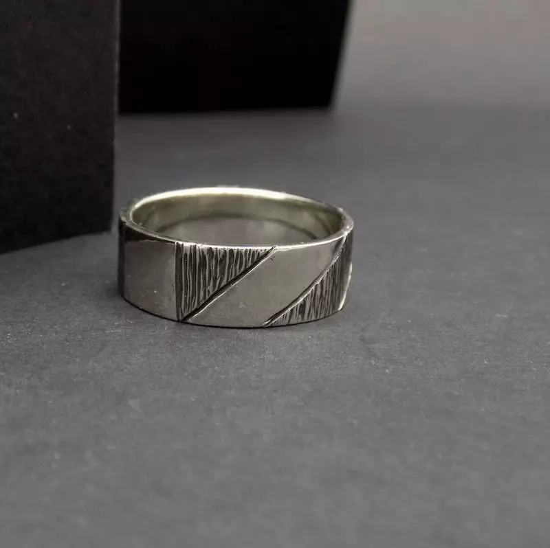 Photo d'une bague en argent 925 posée sur un fond noir