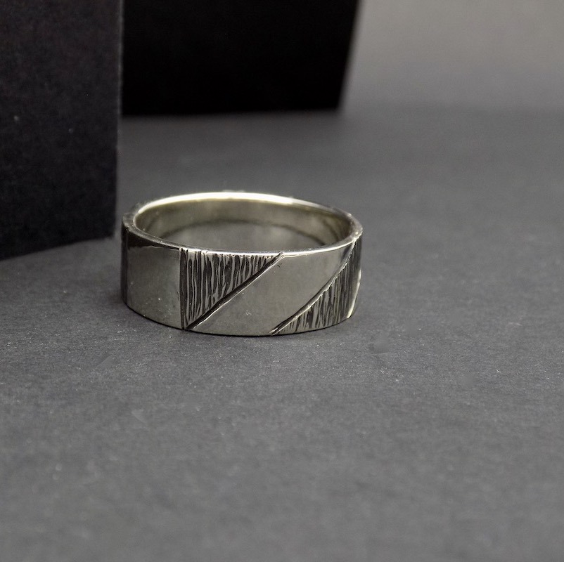 Photo d'une bague en argent 925 posée sur un fond noir