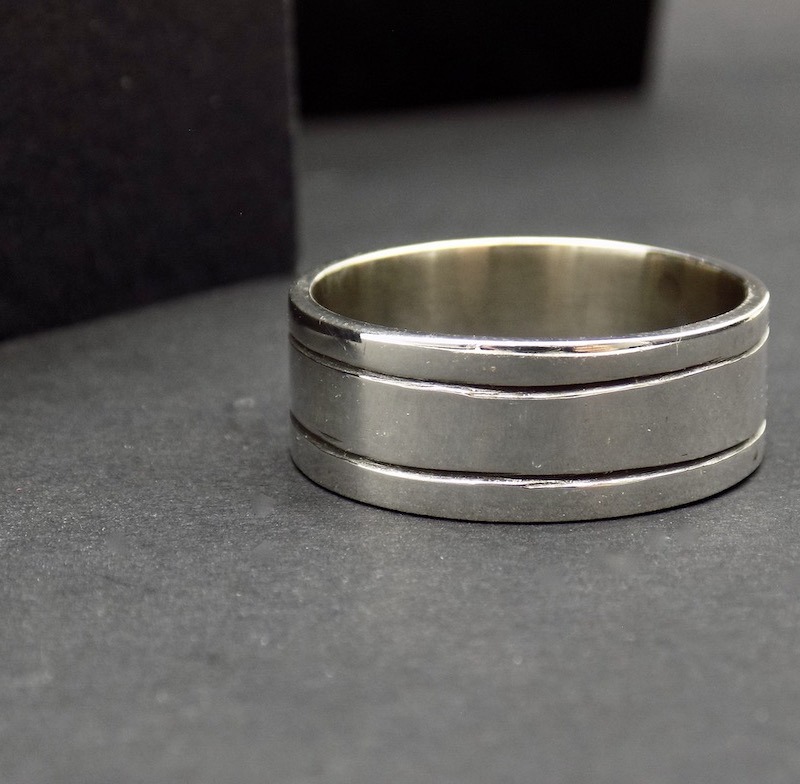 Photo gros plan sur un fond noir d'une bague large pour homme