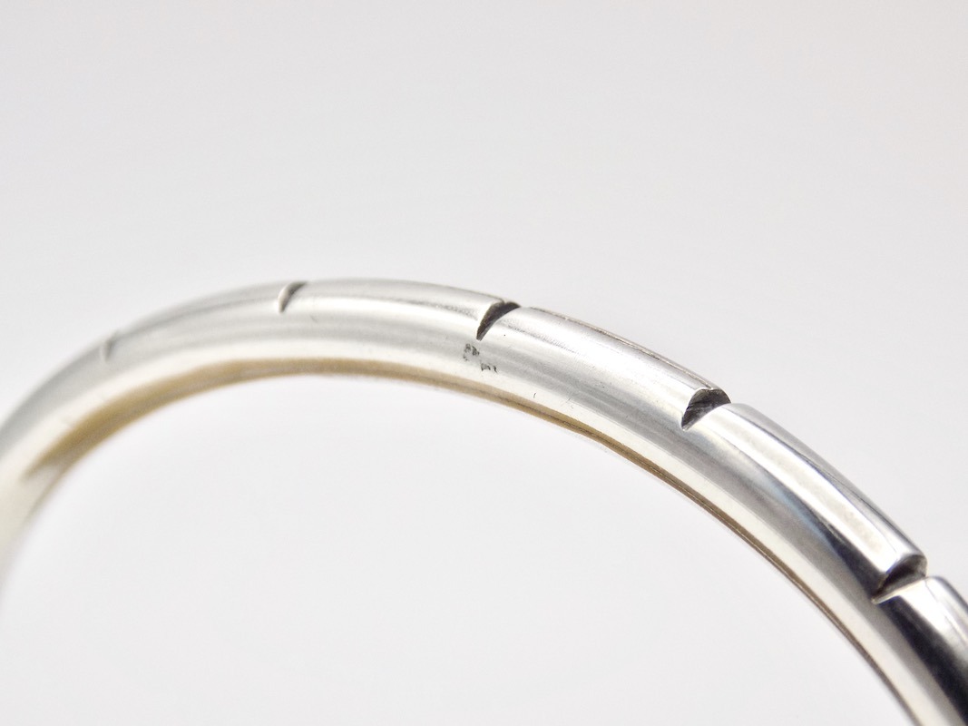 Photo gros plan des ciselures d'un bracelet jonc ouvert fabriqué en argent 925 pour homme