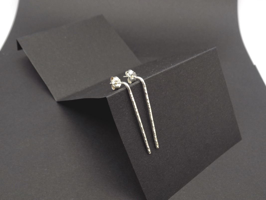 Photo d'une paire de boucles d'oreilles en argent 925 longiligne légèrement martelée. Filo