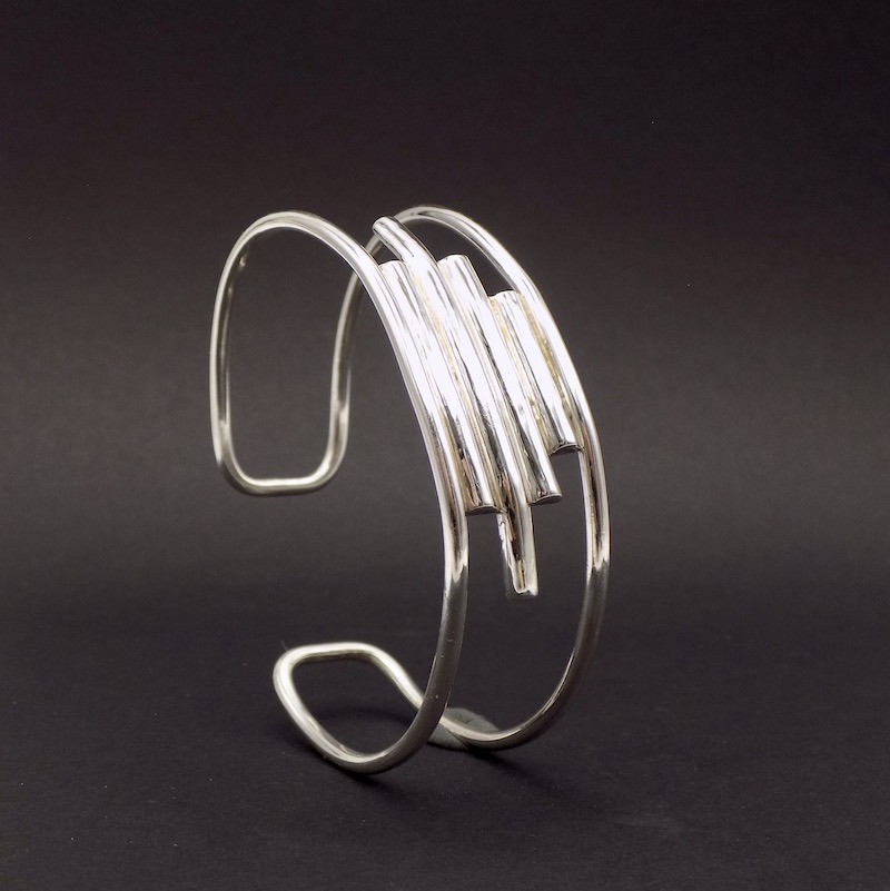 Photo d'un bracelet large dit manchette en argent 925 sur un fond noir.