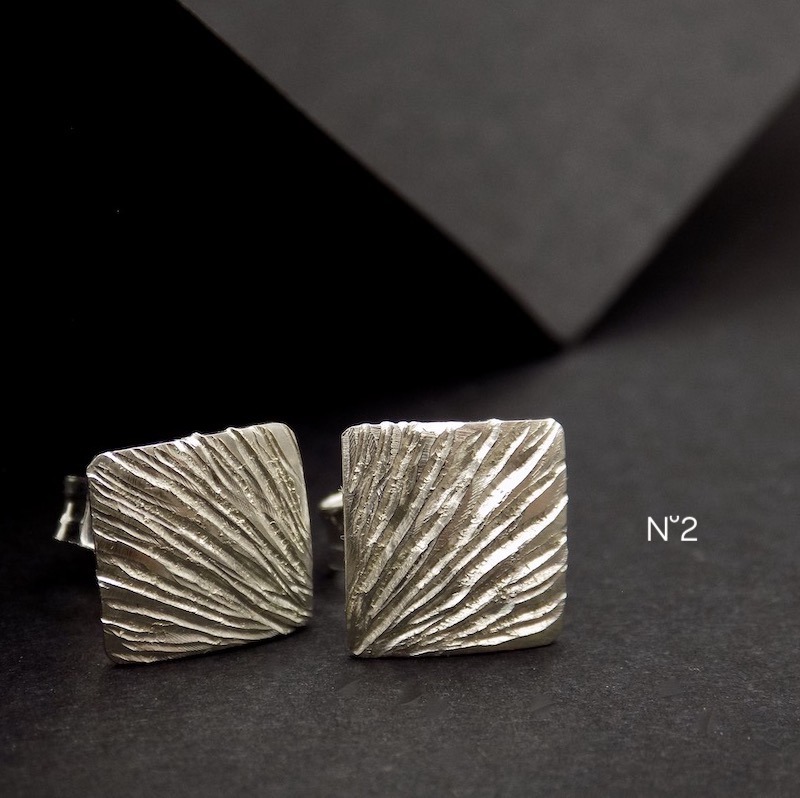 Gro plan sur le travail de ciselure sur une paire de boucles en argent
