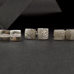 Photo de trois paires de boucles d'oreilles en argent 925. Boucles de formes carrées qui ont été ciselées.