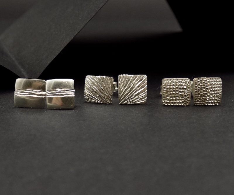 Photo de trois paires de boucles d'oreilles en argent 925. Boucles de formes carrées qui ont été ciselées.