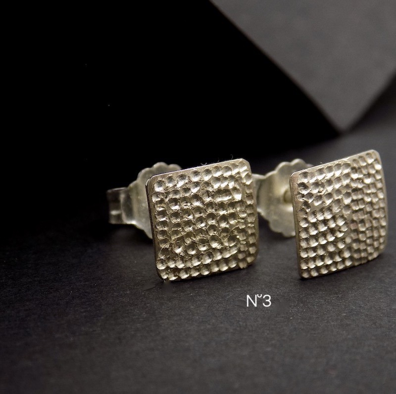 Photo d'un gros plan du travail de surface d'une paire boucles carrées en argent 925